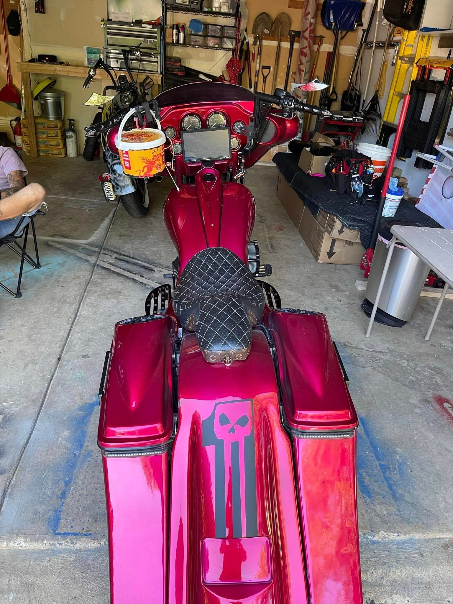 Red custom motorcycle with a skull graphic parked in a garage.