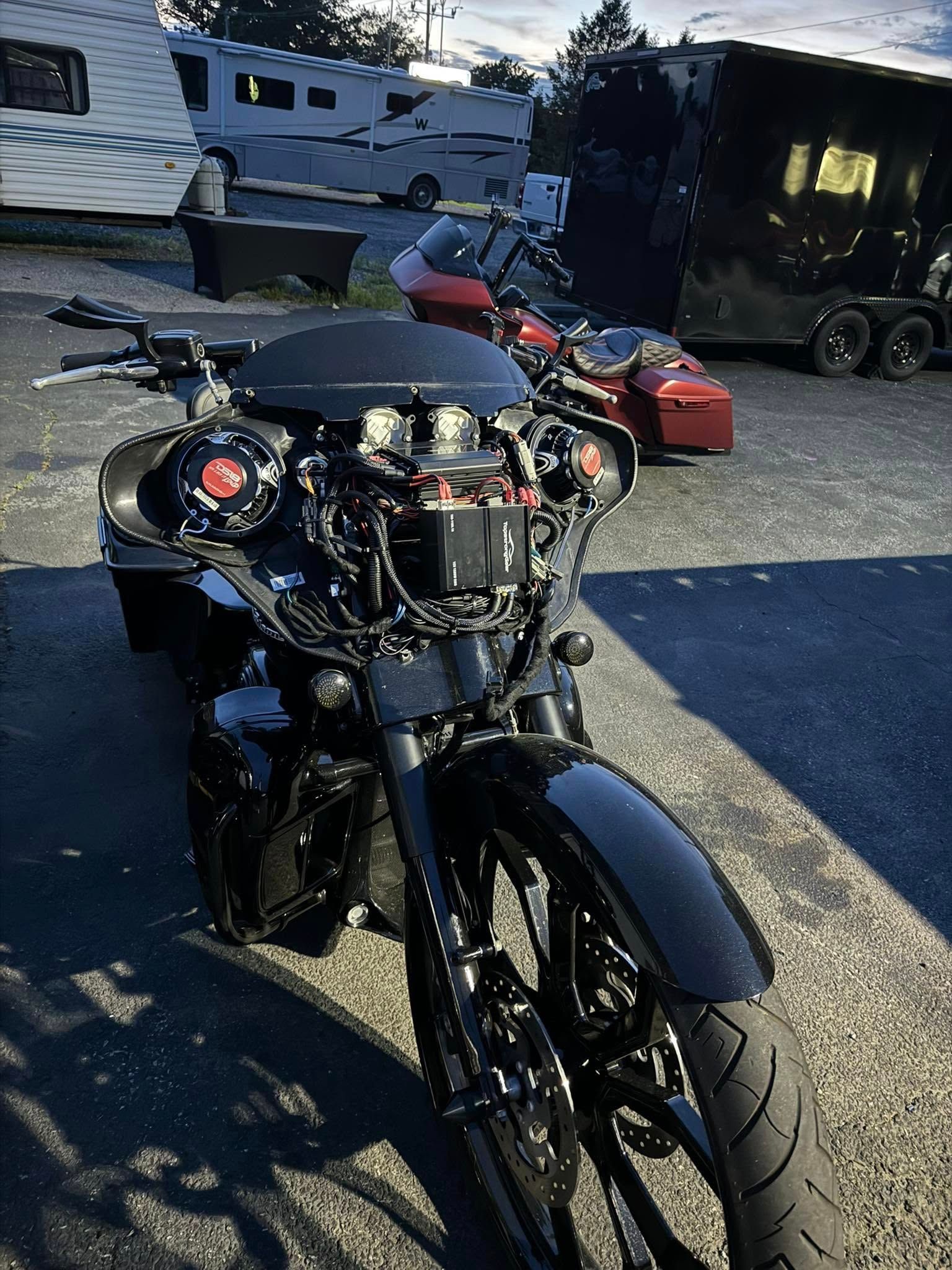 Black custom motorcycle with fairing, parked outdoors.
