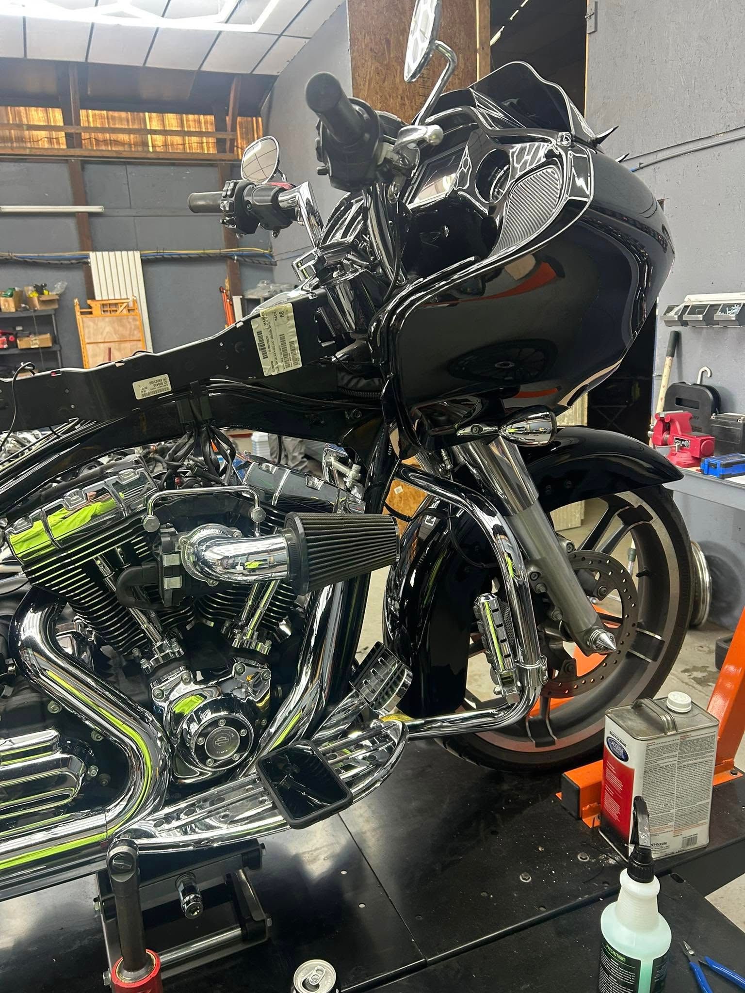 Black and chrome motorcycle on a lift in a garage.