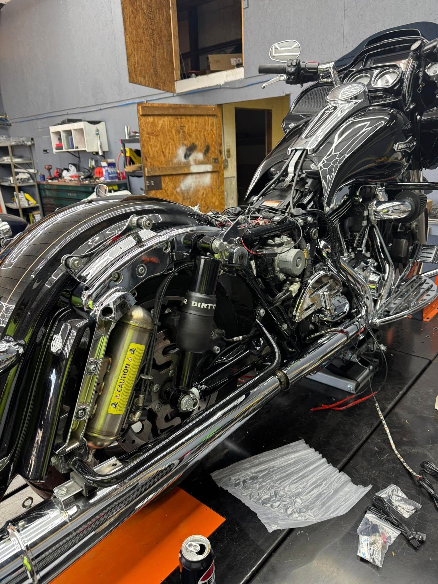 Black and chrome motorcycle in a garage, partly disassembled.