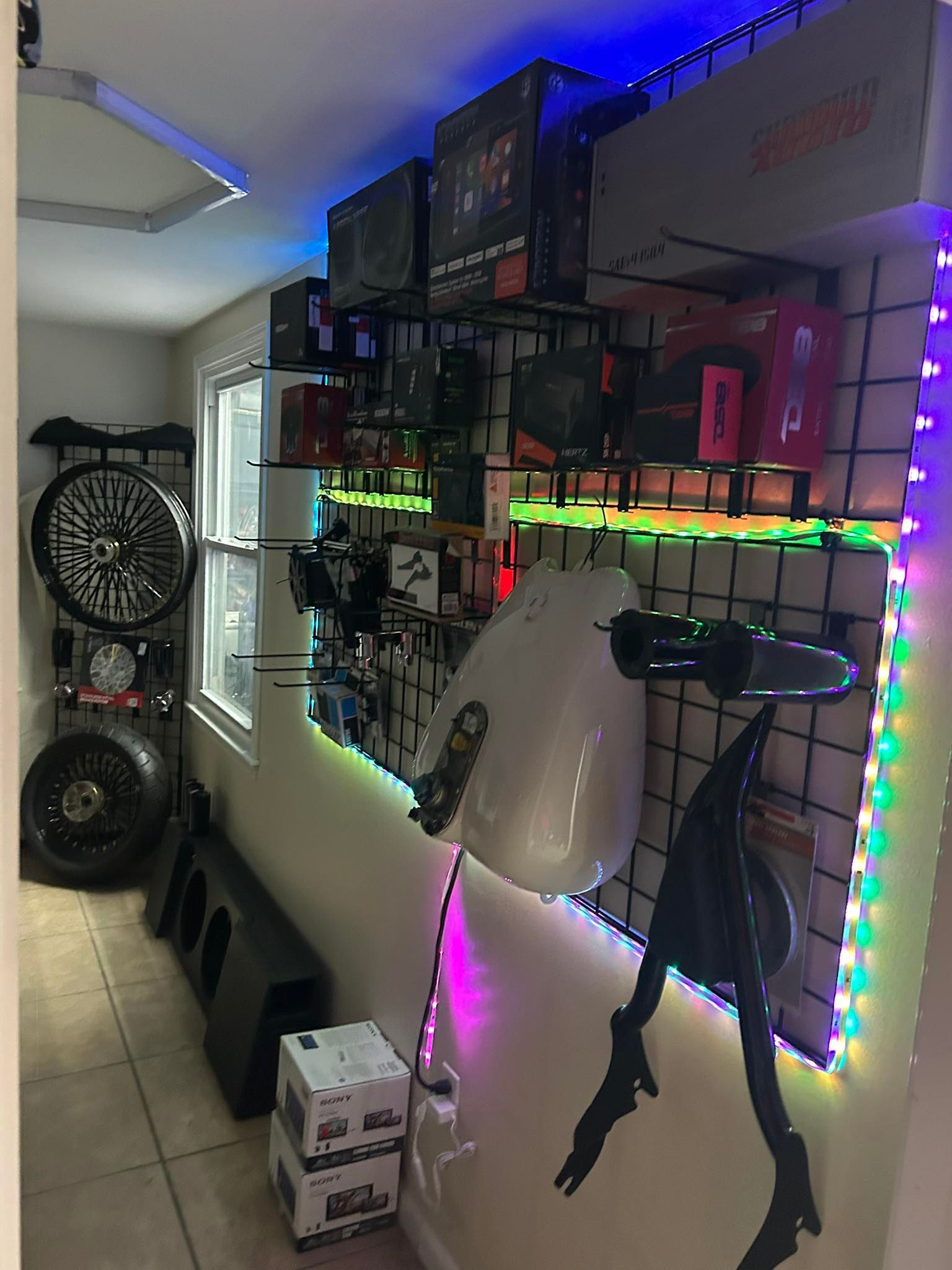 Car parts retail display with shelves of electronics and accessories, lit with colorful LEDs.
