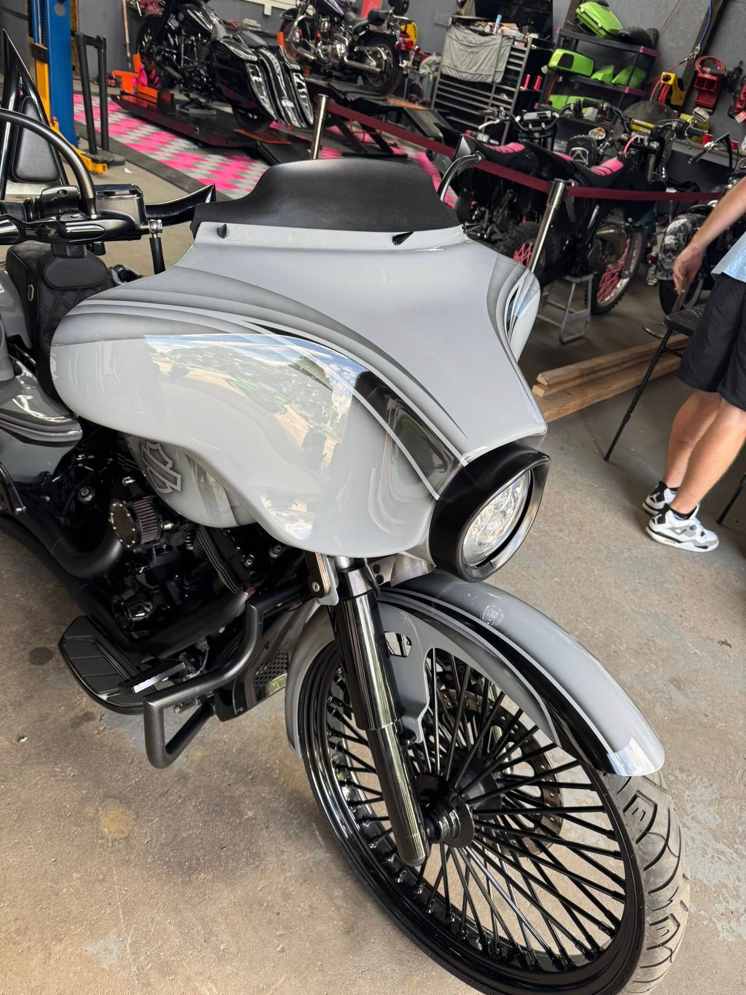 Grey custom motorcycle with black accents and spoked wheels.