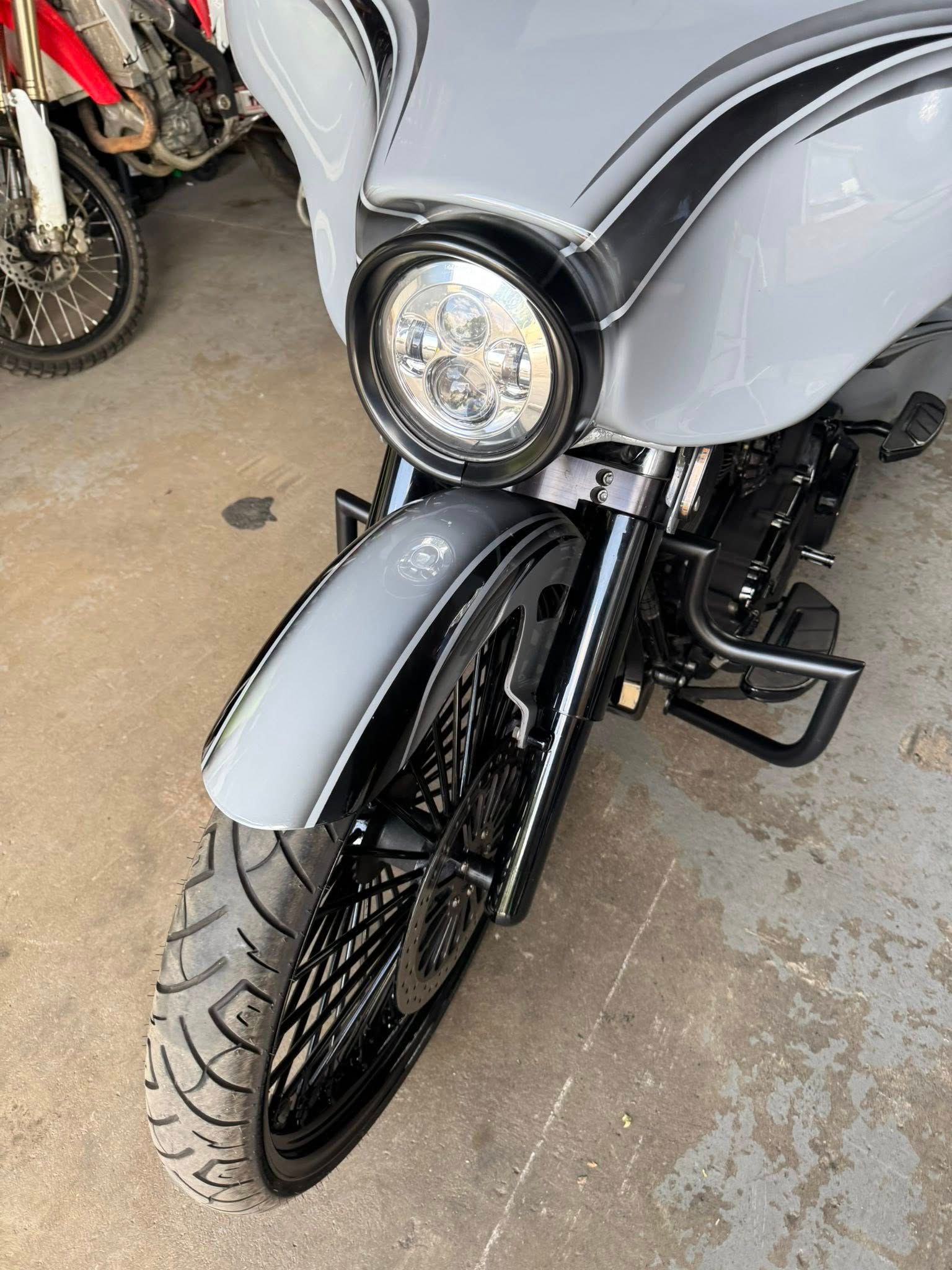 Gray motorcycle with black accents, parked indoors. Front view.