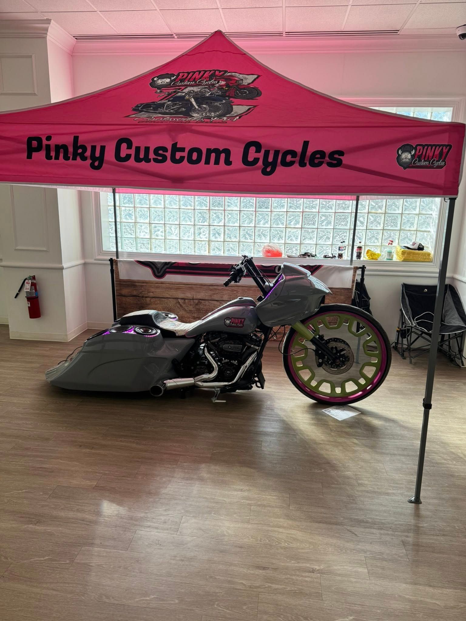 Pinky Custom Cycles booth with a gray custom motorcycle on display.