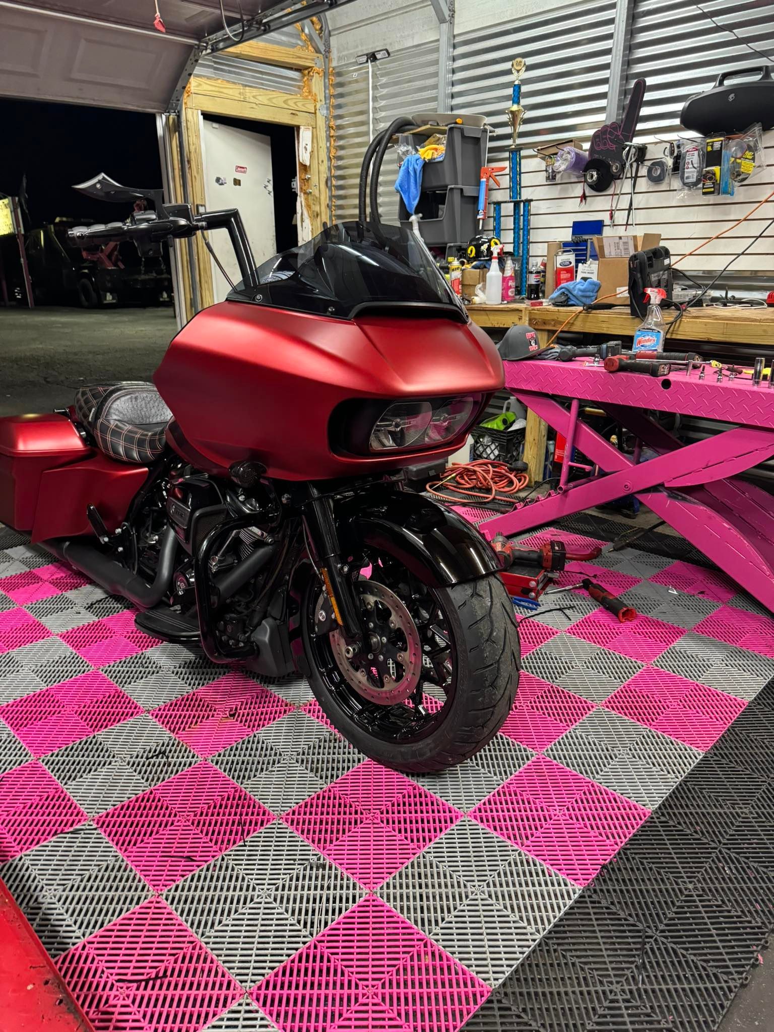 Red motorcycle with black accents parked on pink and gray checkered floor.