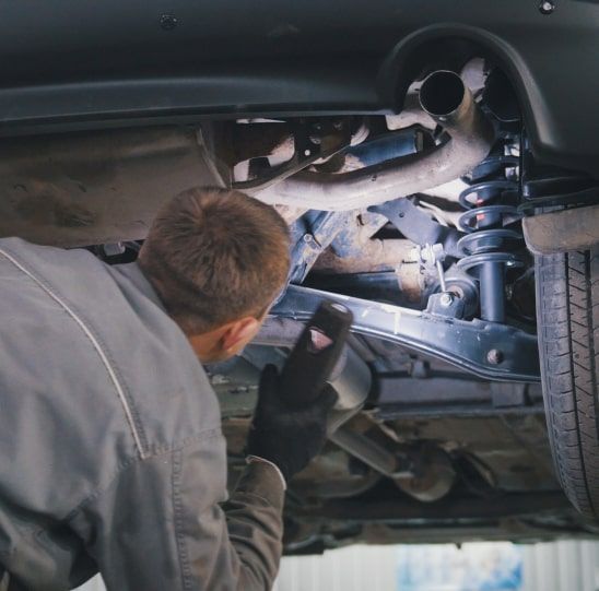 A mechanic working on a vehicle | Community Automotive Repair