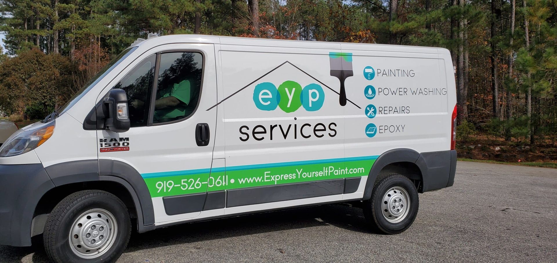 A white van with the word services on the side is parked in a gravel lot.