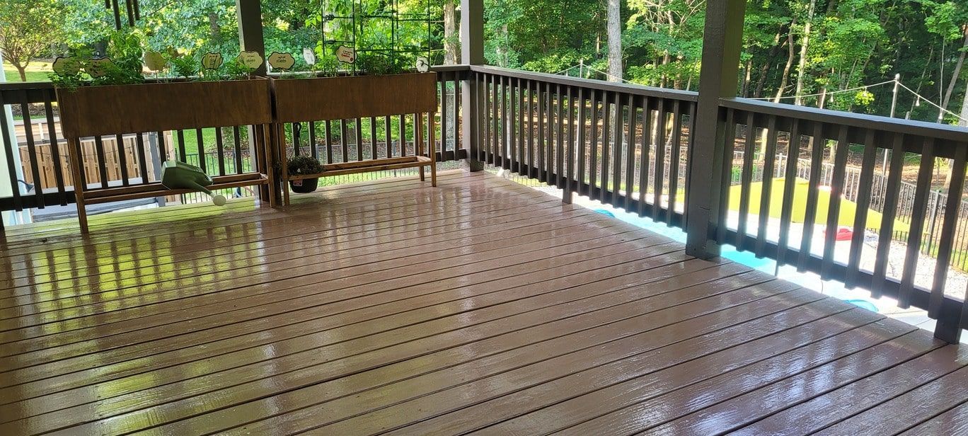A wooden deck with a bench and a planter on it.