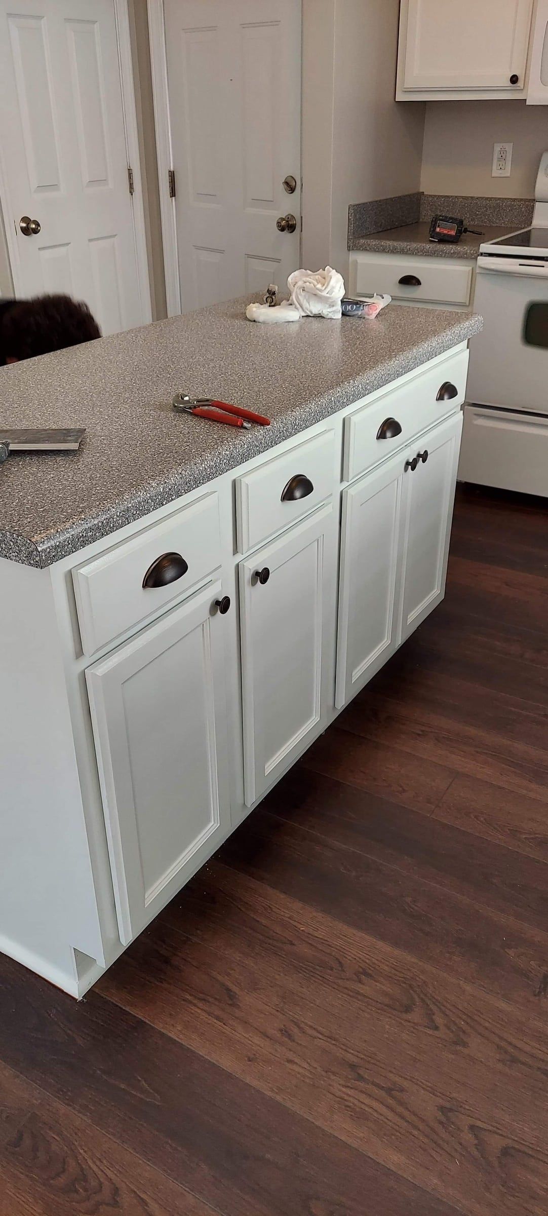 A kitchen with white cabinets and granite counter tops.