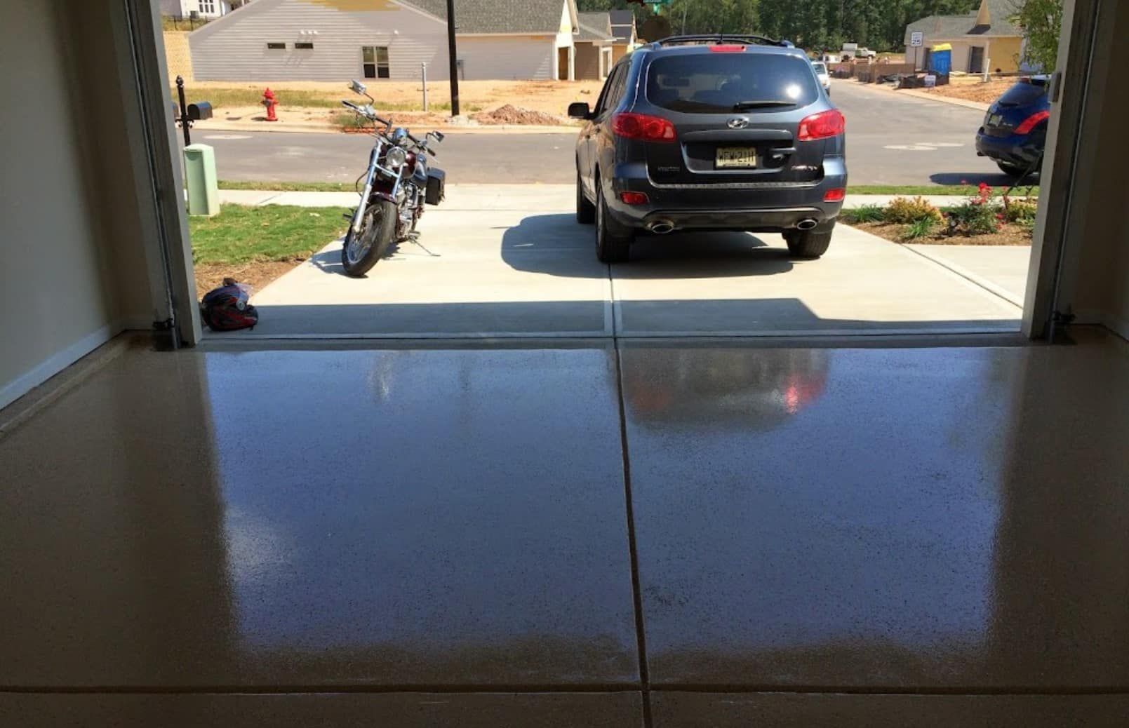 A car is parked in a garage next to a motorcycle.
