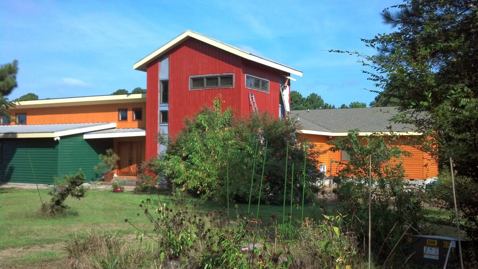 A red house with a green garage in front of it