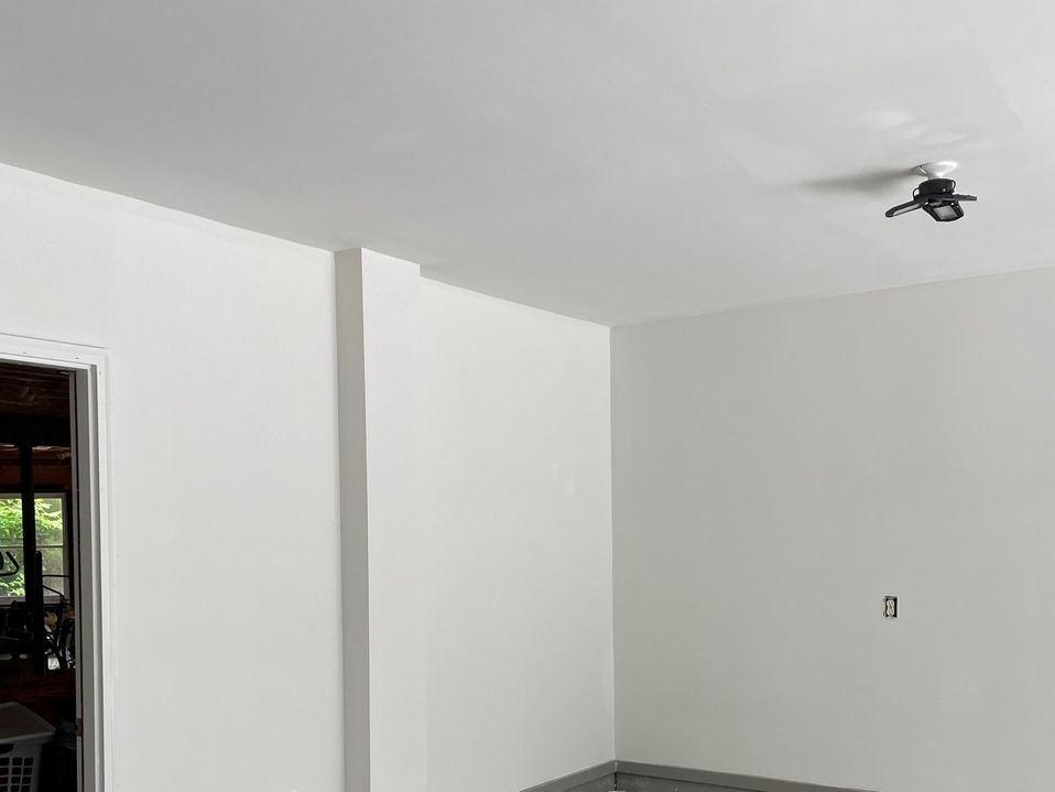 A room with white walls and a ceiling fan.