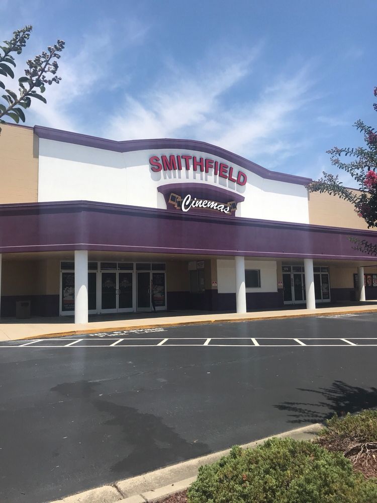 A smithfield store with a purple awning and a parking lot in front of it.