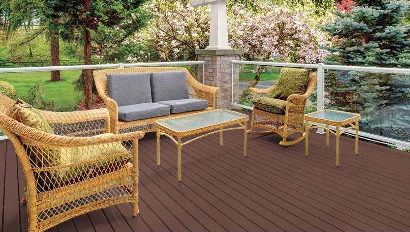 A wooden deck with wicker furniture and a couch.