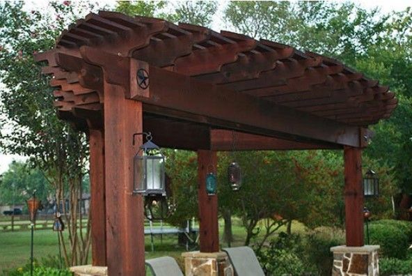 A wooden pergola with chairs underneath it