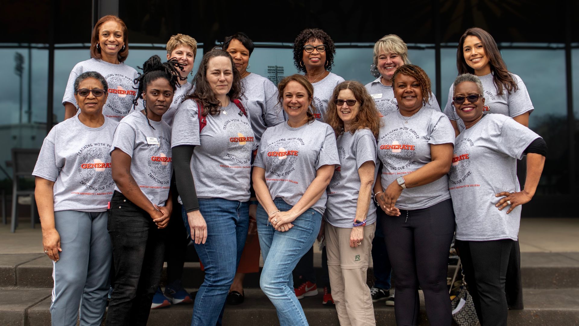 A group of women are posing for a picture in front of a building.