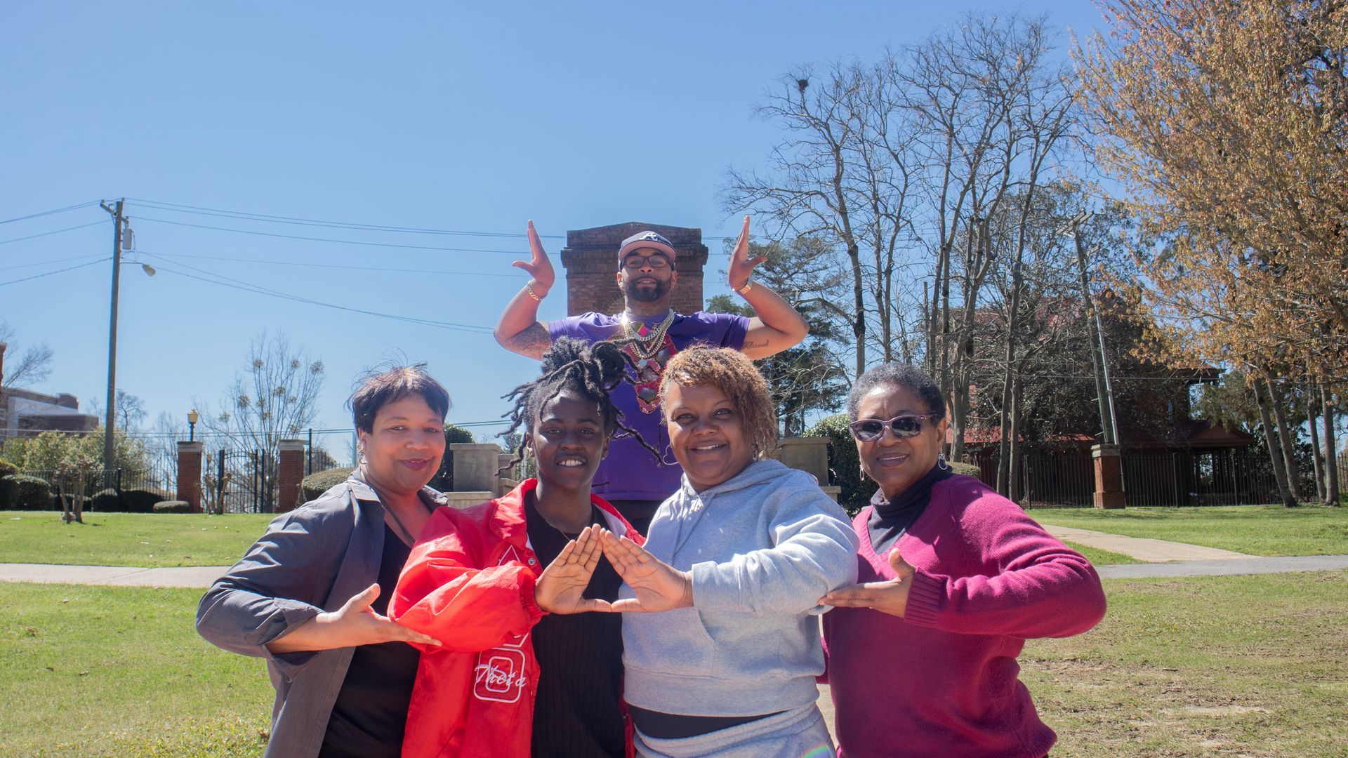 A group of people are posing for a picture in a park.