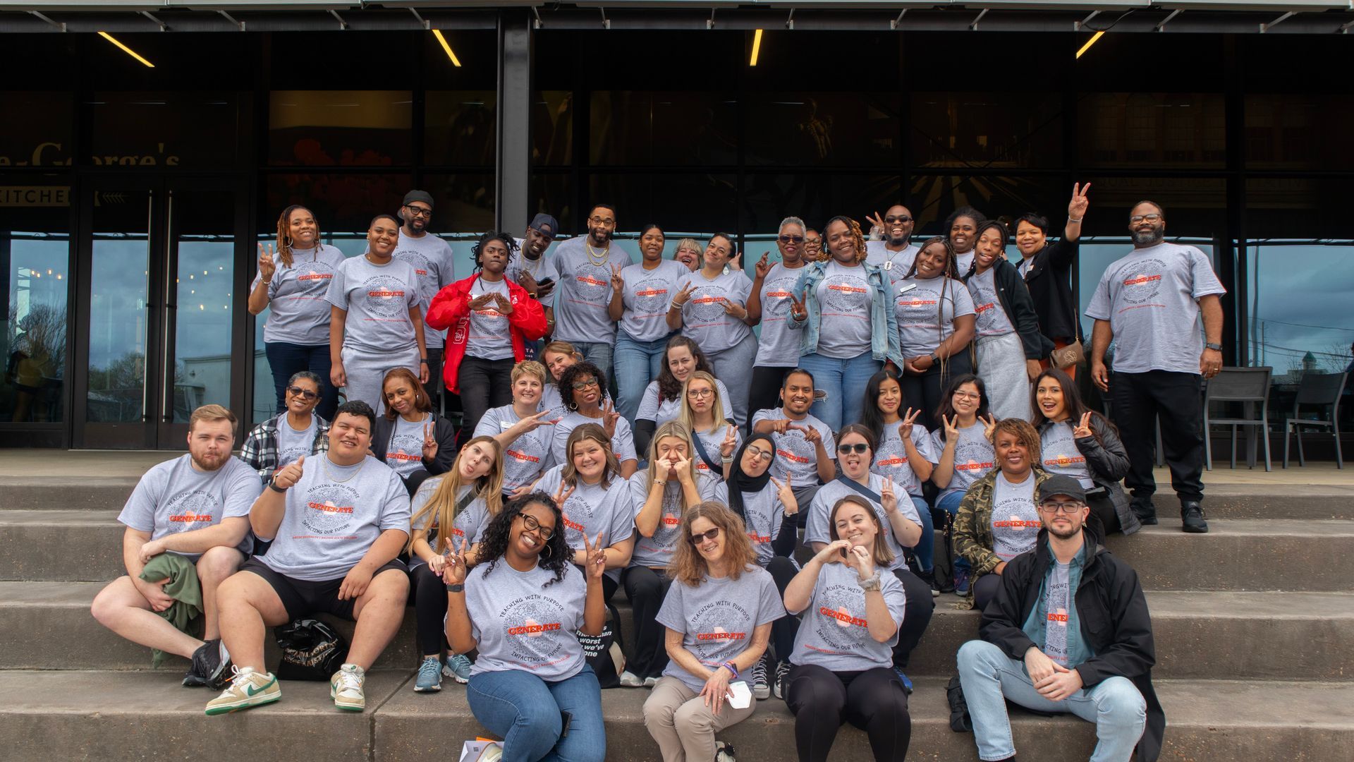 A large group of people are posing for a picture on the steps of a building.