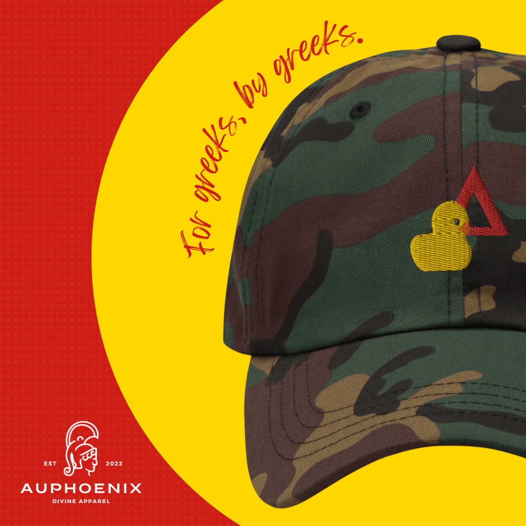 A camouflage hat with a yellow duck and the words