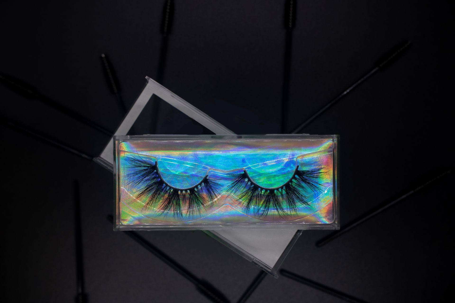 A pair of false eyelashes in a box on a black background.