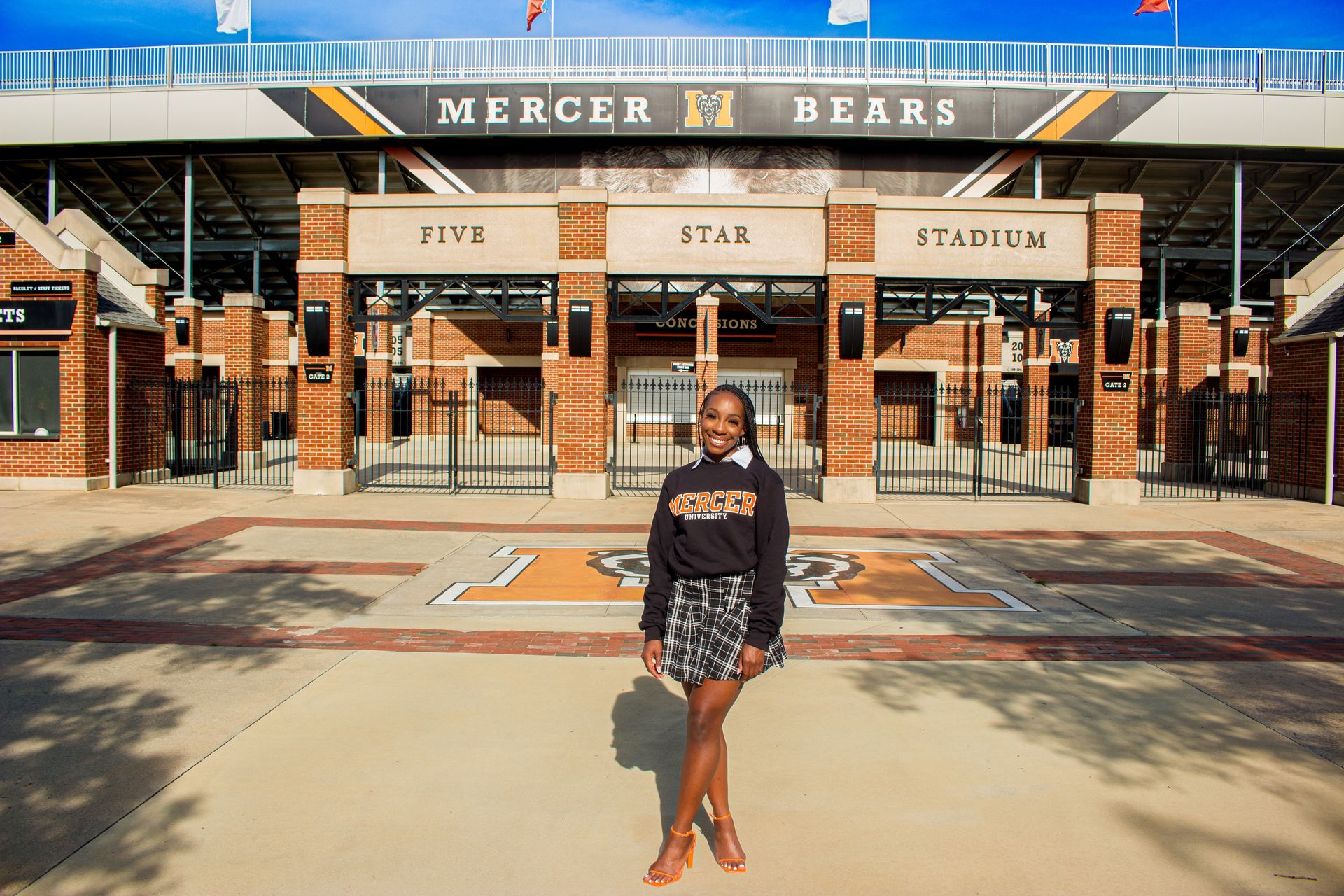 A woman is standing in front of a stadium.