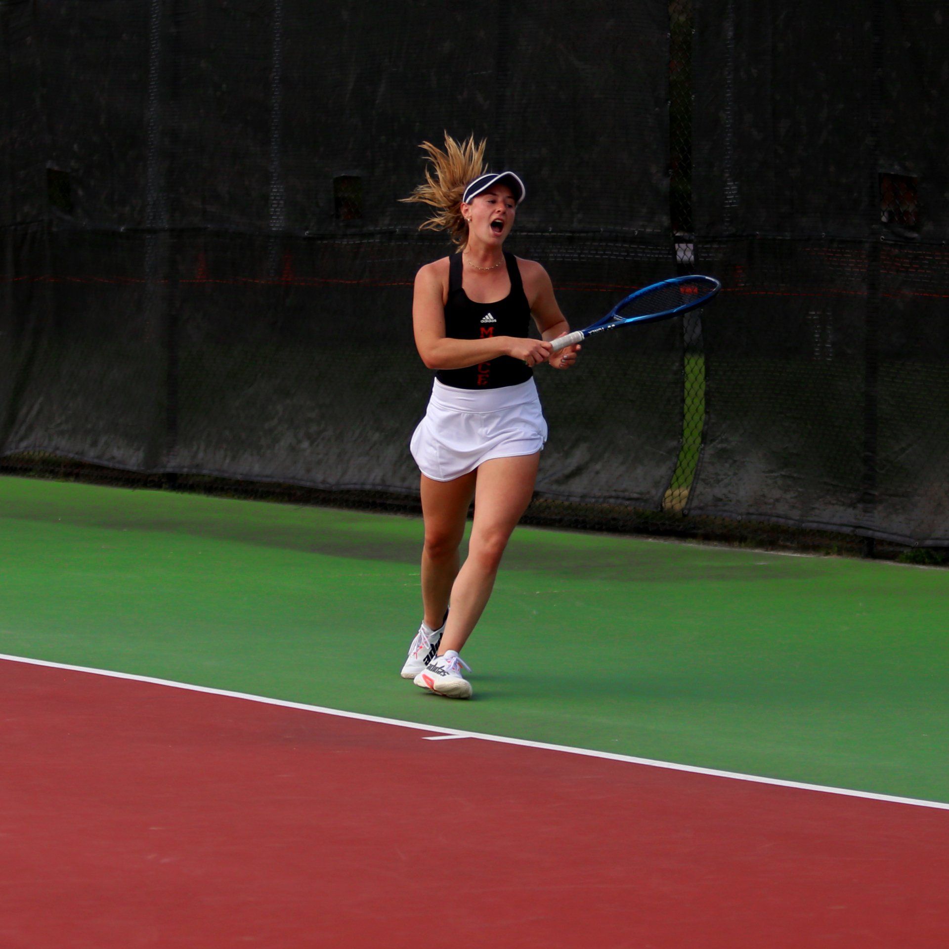 A woman is holding a tennis racquet on a tennis court