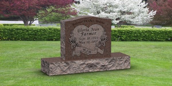 A gravestone in a cemetery with a heart on it.