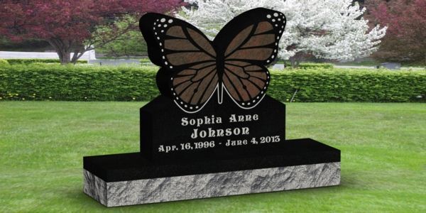 A black gravestone with a butterfly on it