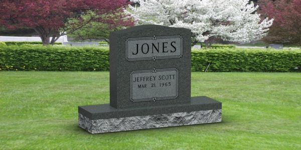 A black gravestone in a cemetery with the name jones on it.