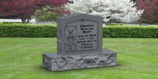 A gravestone in a cemetery with a teddy bear on it.
