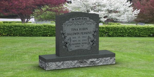 A gravestone in a cemetery with a tree in the background.