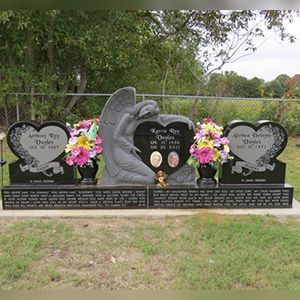 A couple of graves with flowers on them in a cemetery.