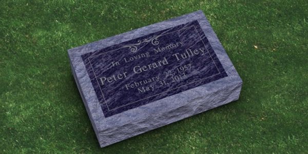 A gravestone for peter gerard tullys is sitting on top of a lush green field.