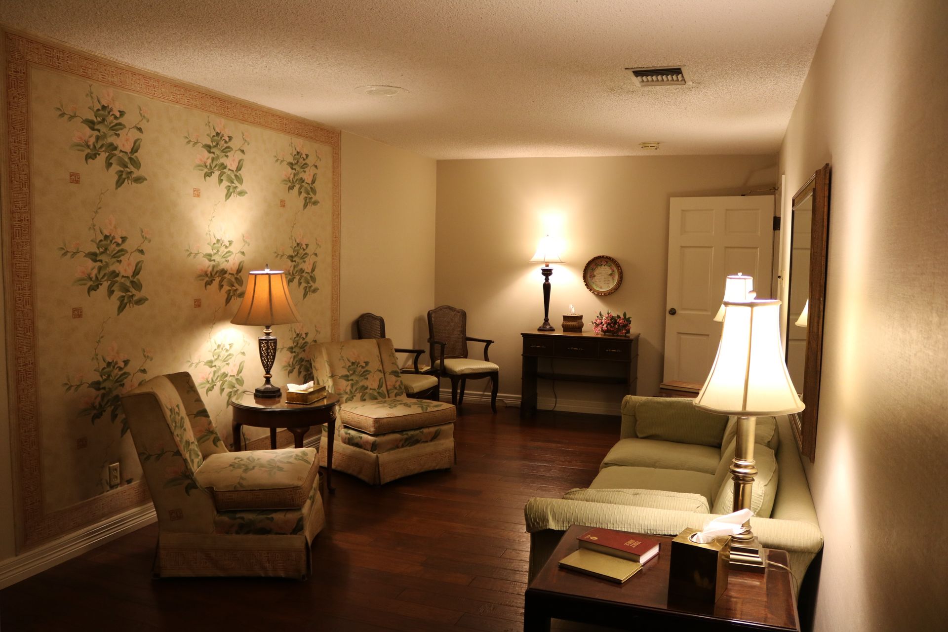 A living room with a couch , chairs and lamps