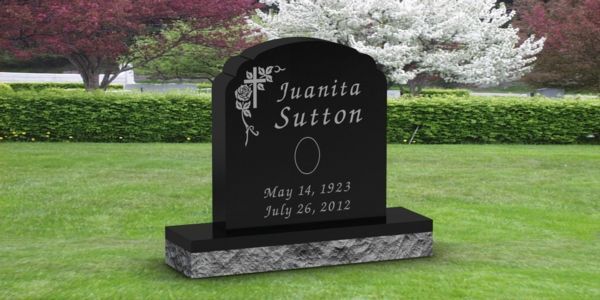 A black gravestone with the name juanita sutton on it