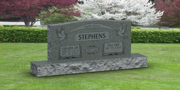 A gravestone for stephens is sitting in the middle of a lush green field.