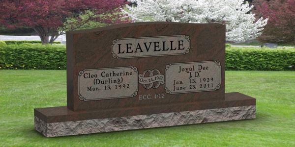 A gravestone for leavelle in a cemetery with flowers in the background.