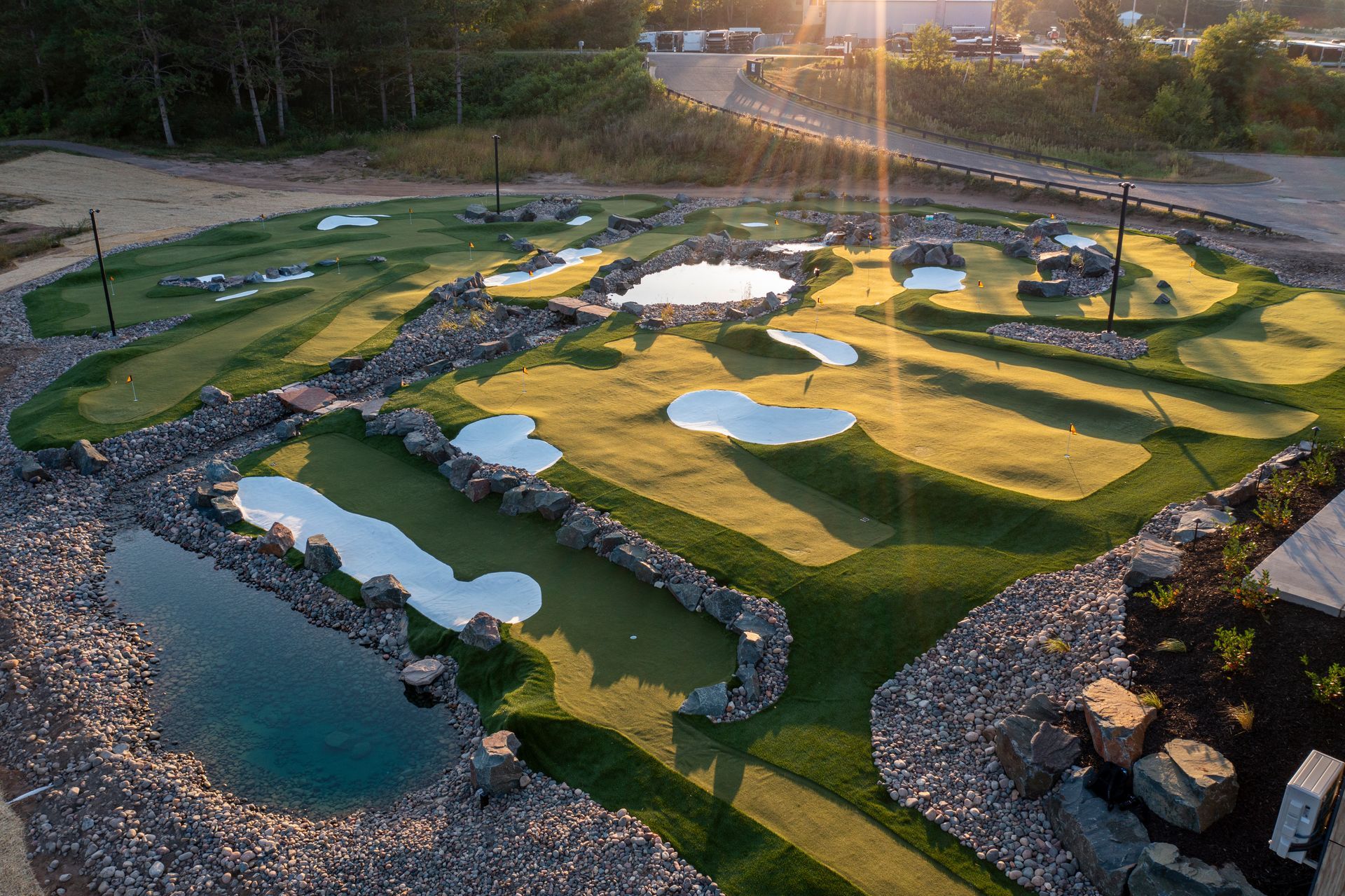 An aerial view of a golf course with a pond in the middle