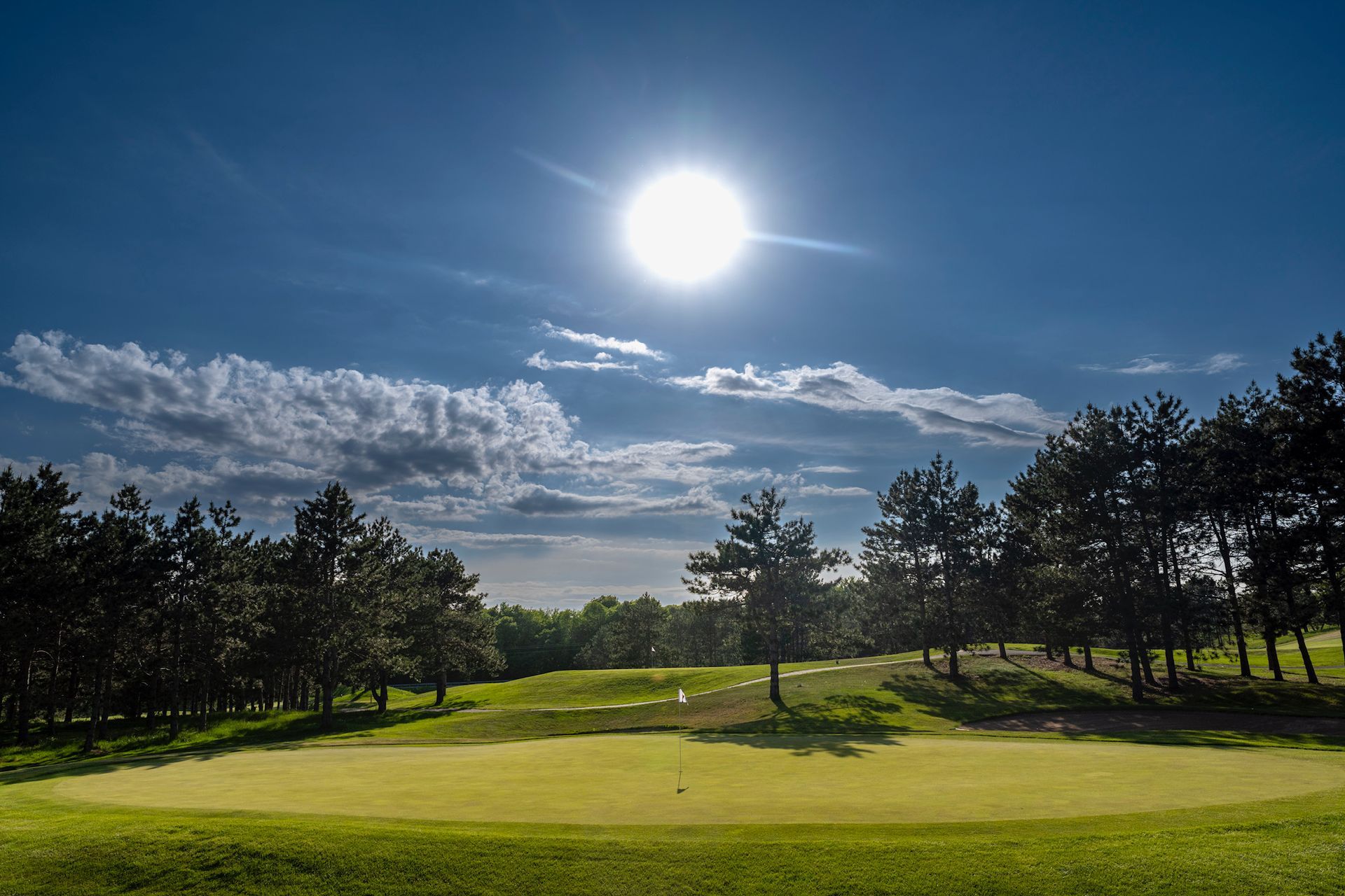 The sun is shining brightly over a golf course