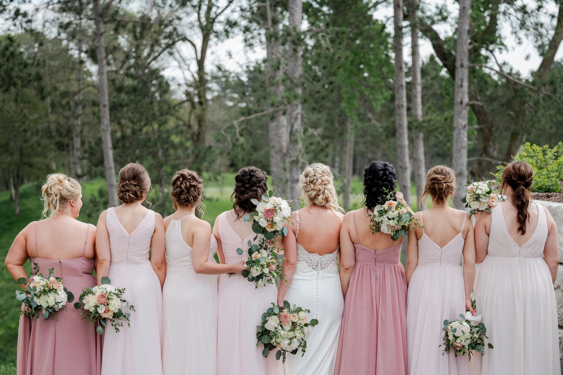 A bride and groom kissing on a bridge with their dog.