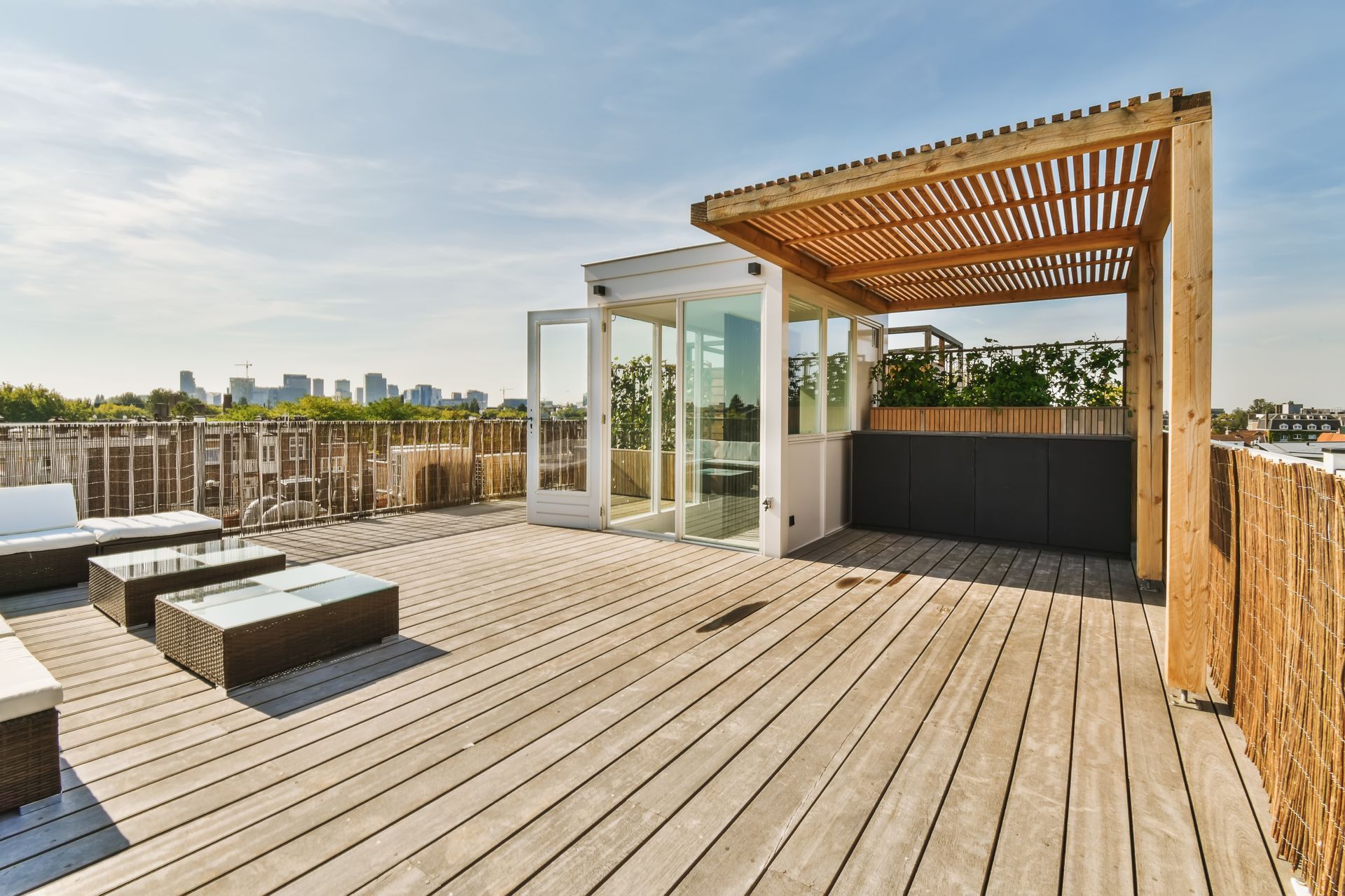 A wooden deck with a pergola and chairs on it.