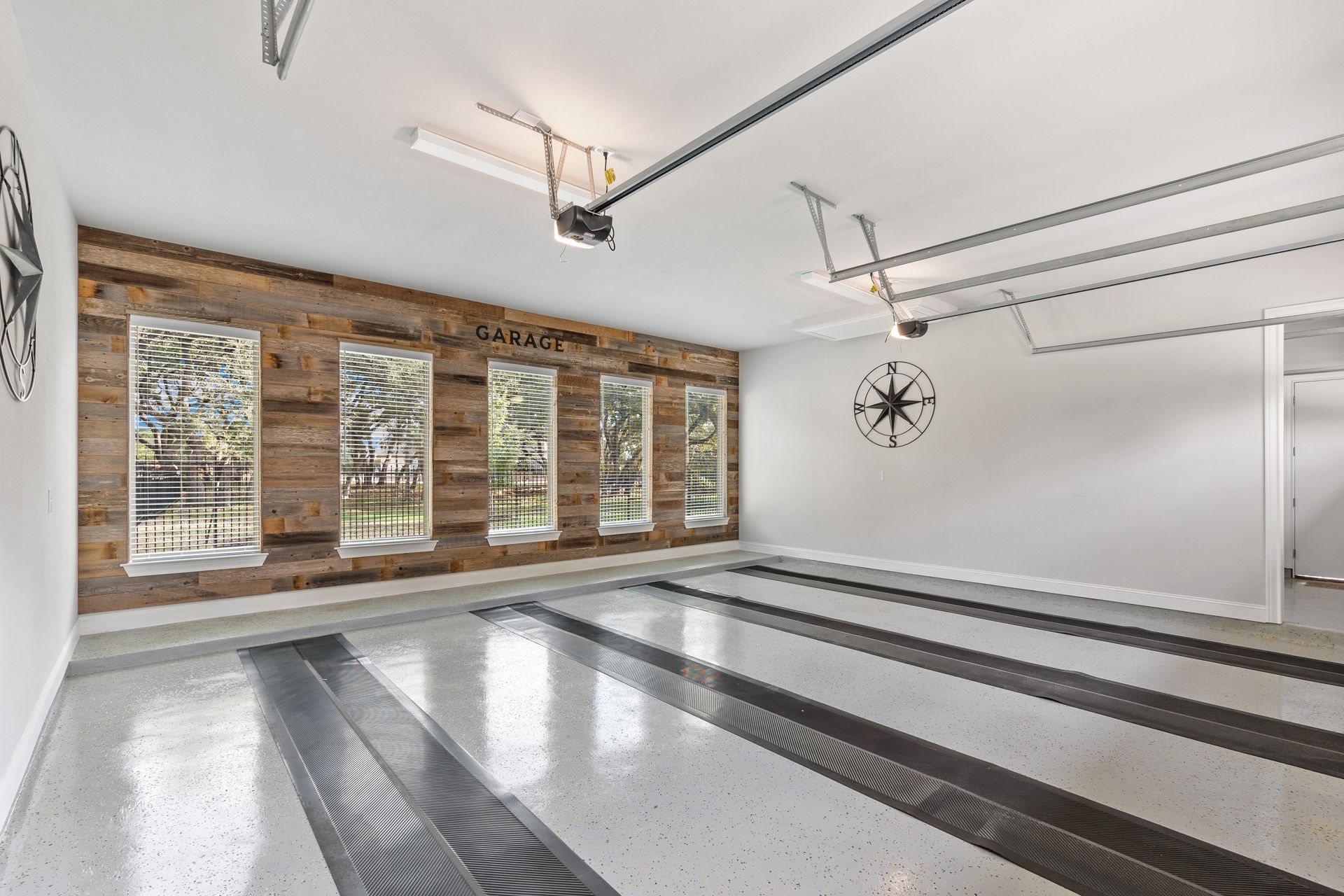 Clean, bright garage with large windows and wood accent wall.