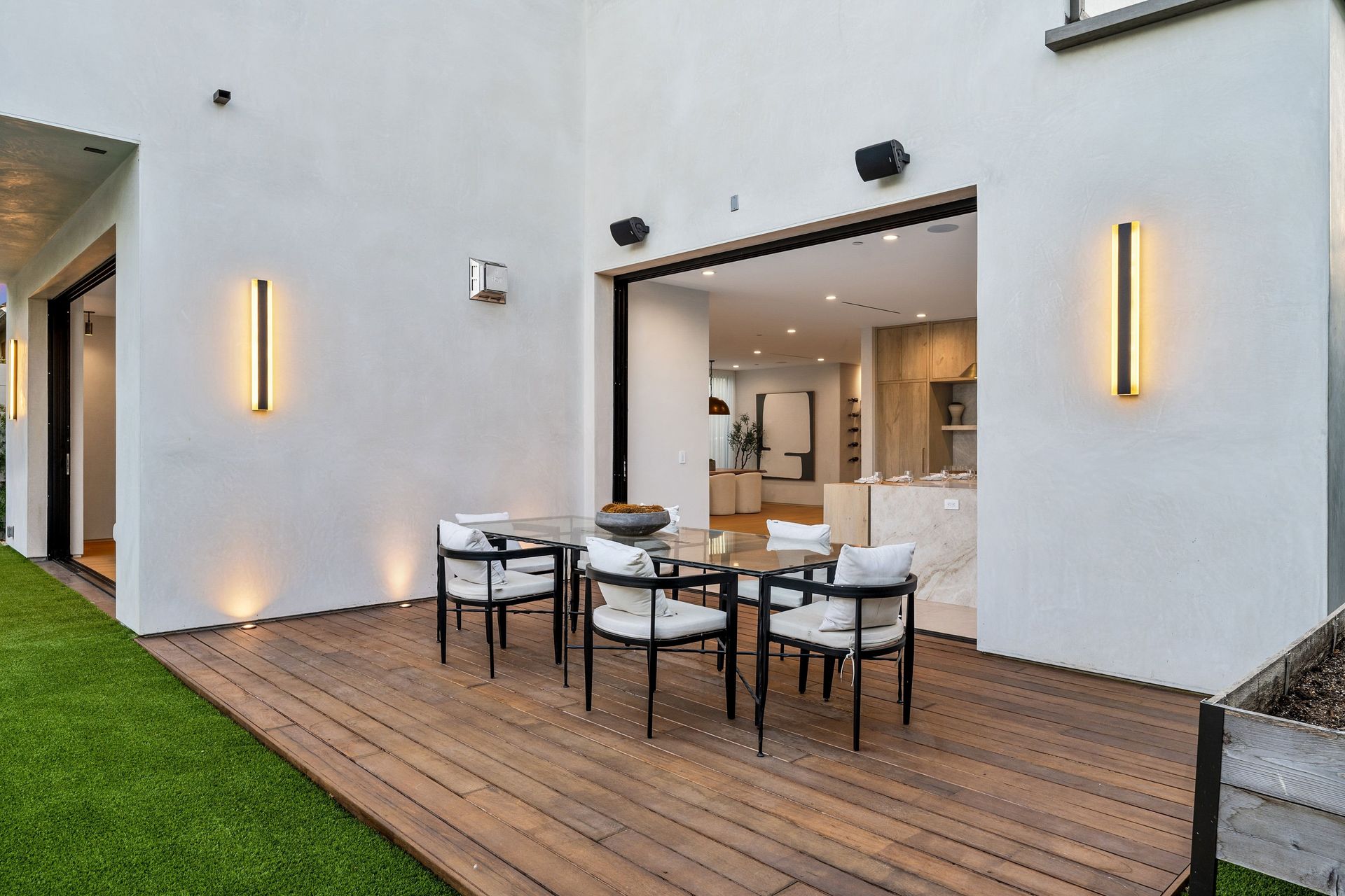 There is a wooden deck with a table and chairs on it.