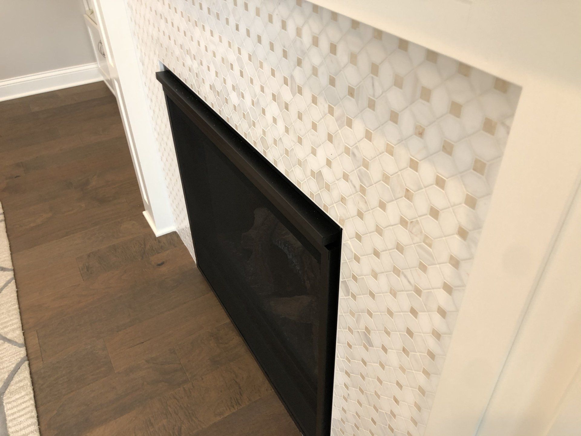 A fireplace with a black screen in a living room.