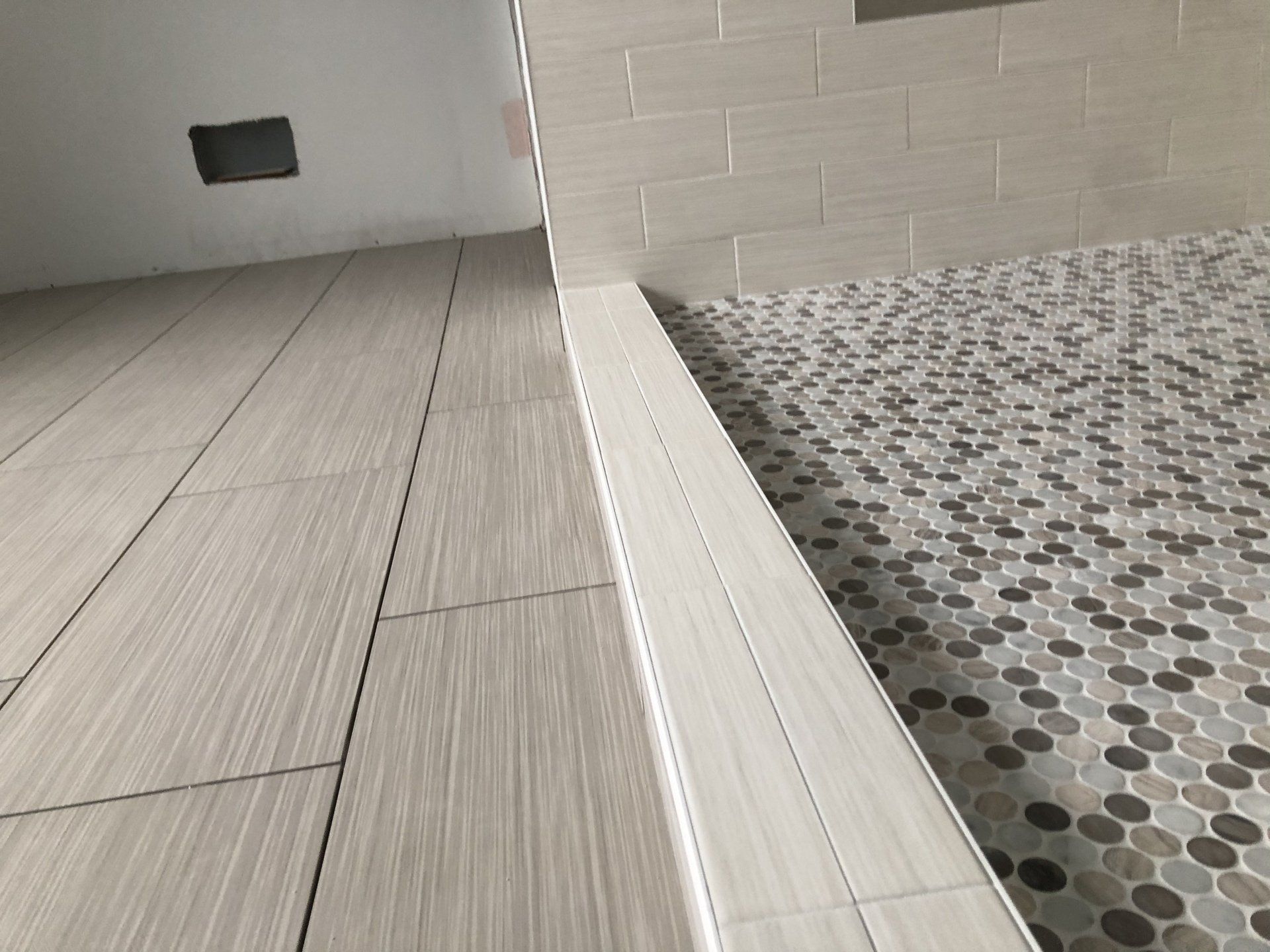 A bathroom with a walk in shower and a tiled floor.