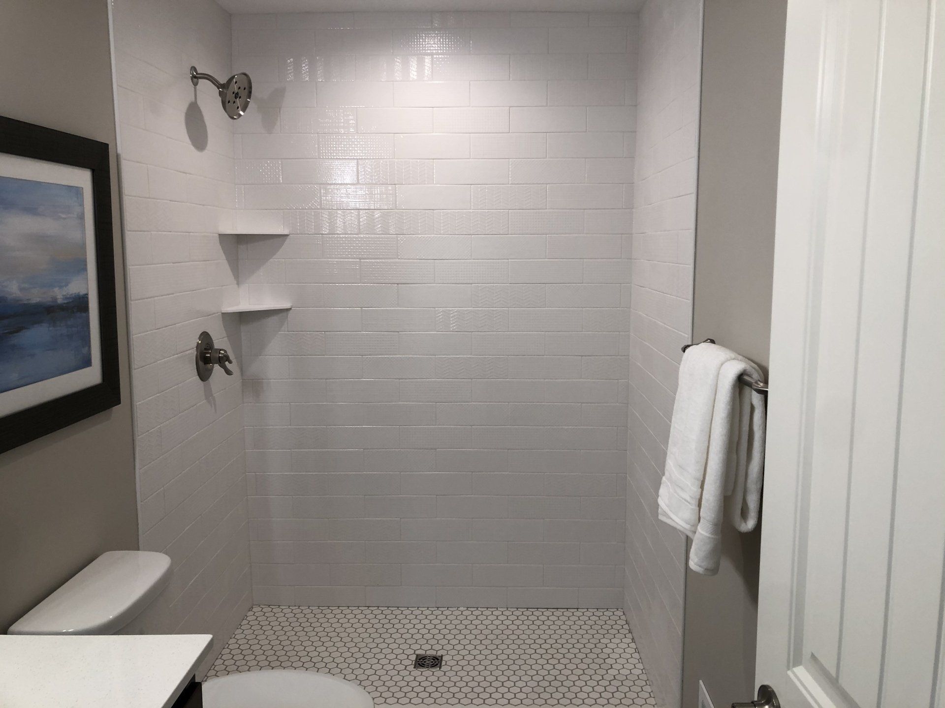 An upgraded bathroom with a walk in shower and a toilet.