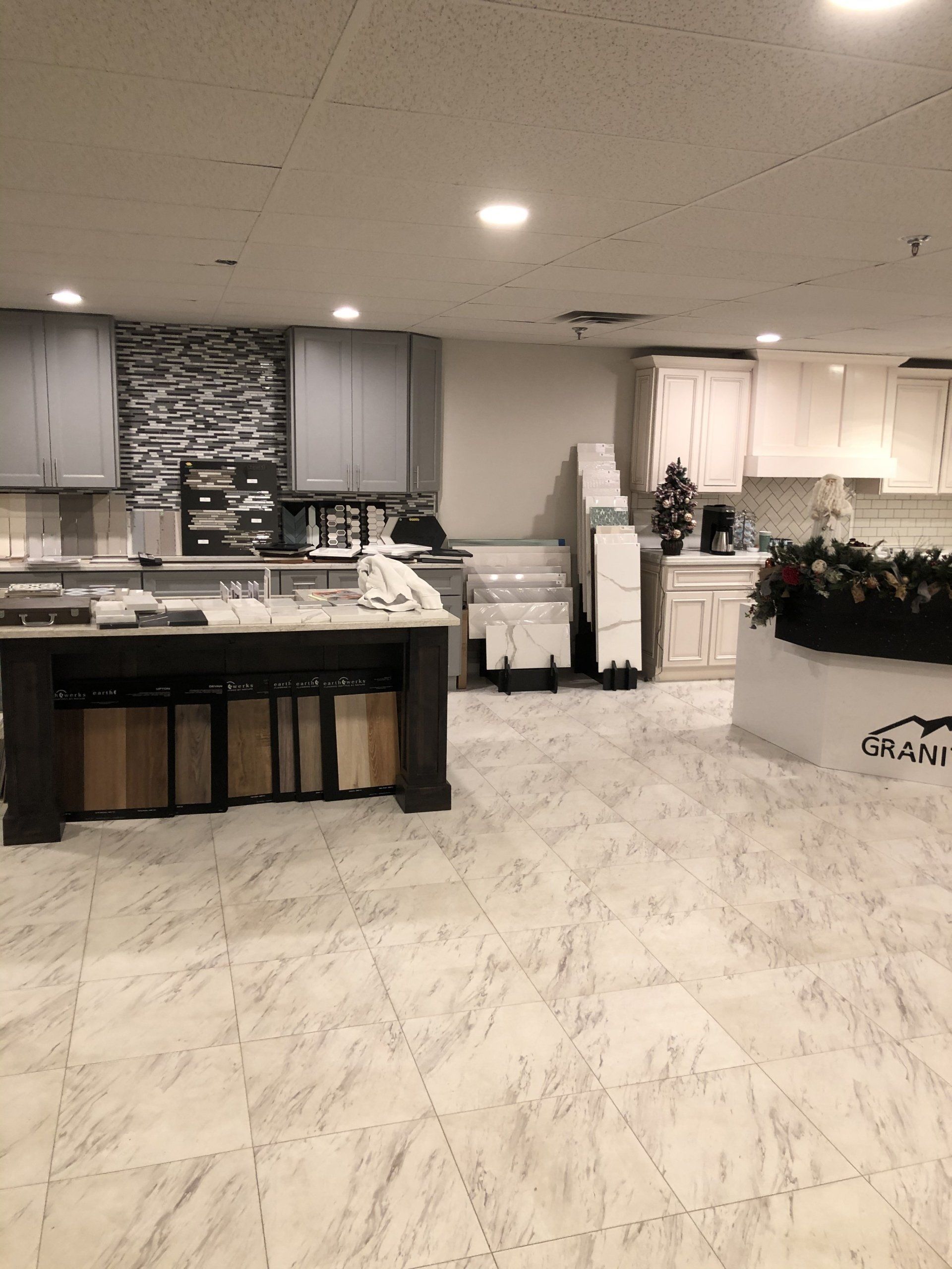 A kitchen with a marble floor and a table in the showroom