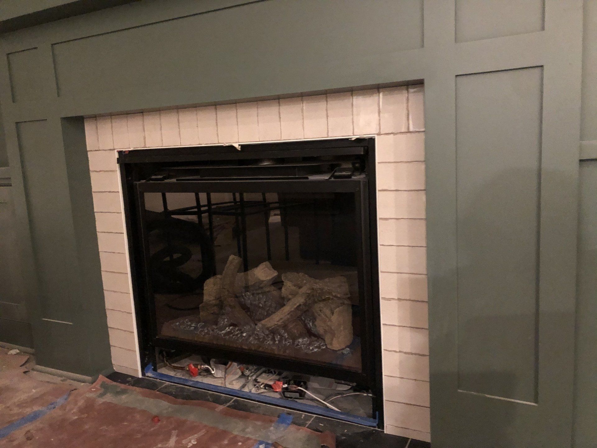A fireplace is being remodeled in a living room.