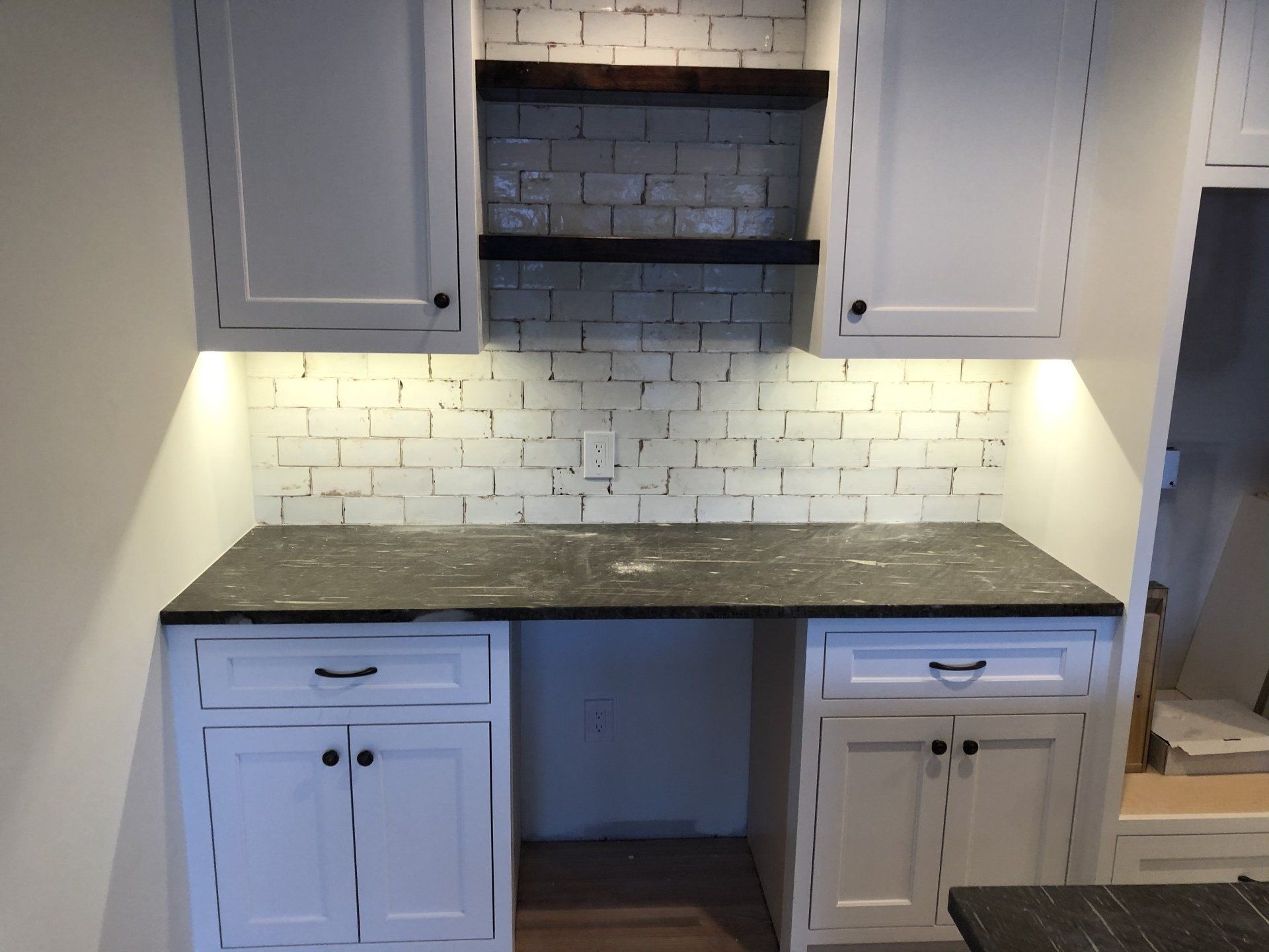 Kitchen cabinetry | A kitchen with white cabinets and black counter tops