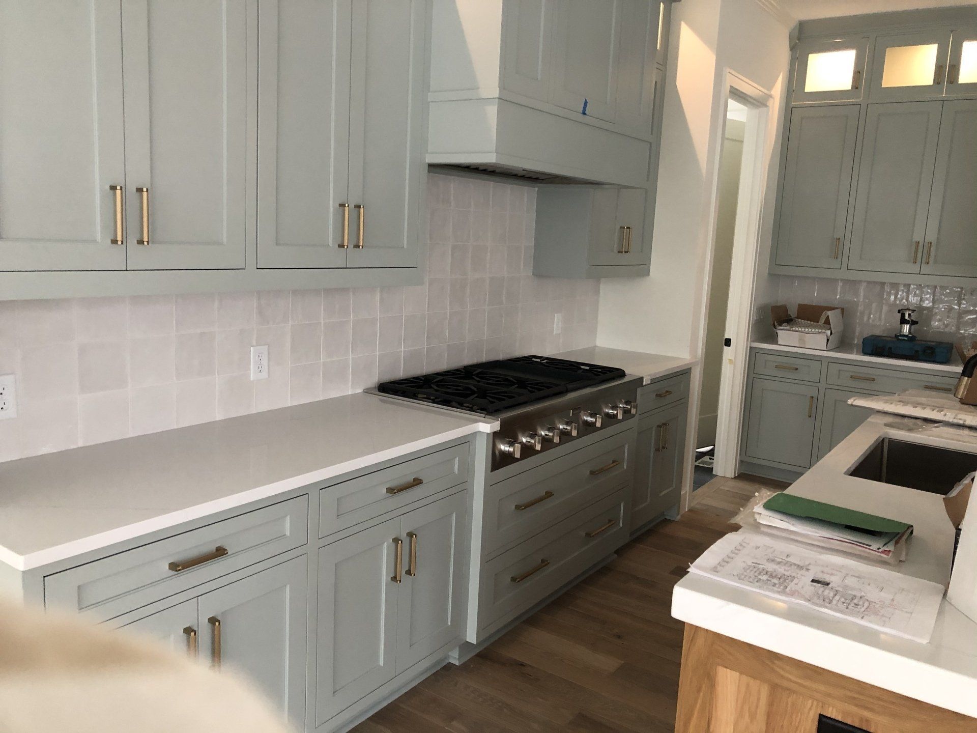 A kitchen with white cabinets and a stove top oven.